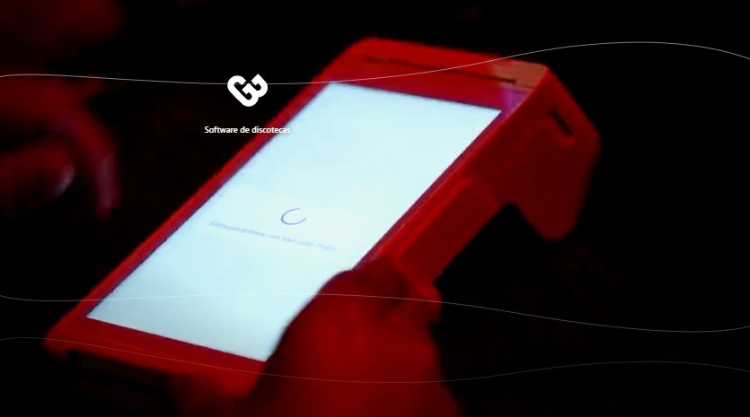 Terminal POS iluminada en la mano del cajero de una discoteca mientras cobra una consumición