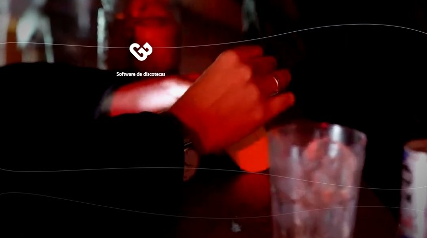 Barra de una discoteca de noche con luz roja: el barman entrega el trago sobre la barra, junto a un vaso con hielo