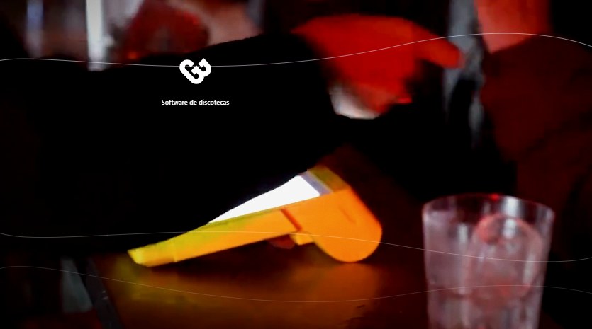 Point de Mercado Pago con la pantalla encendida sobre la barra de un bar nocturno, junto a la mano del cajero y un trago